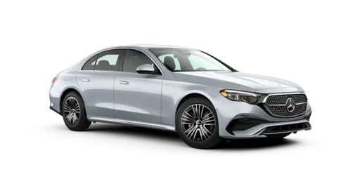 Silver Mercedes-Benz luxury sedan shown in a front three-quarter view, featuring a large illuminated-style grille with the Mercedes emblem, sleek LED headlights, sculpted body lines, alloy wheels, and a modern four-door design isolated against a black background.